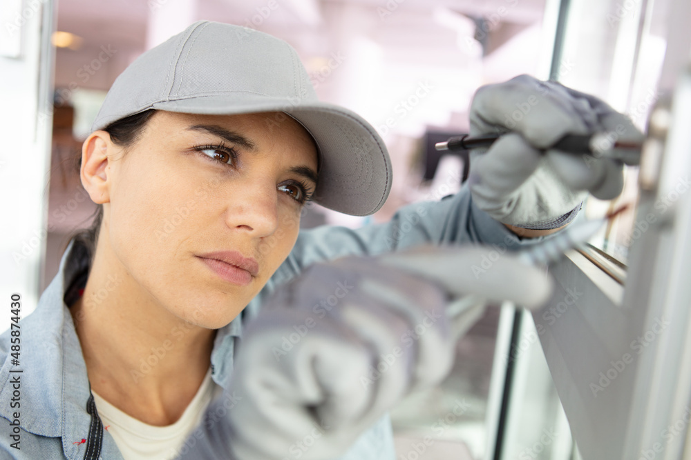 a female builder fixing the window a female builder fixing the window