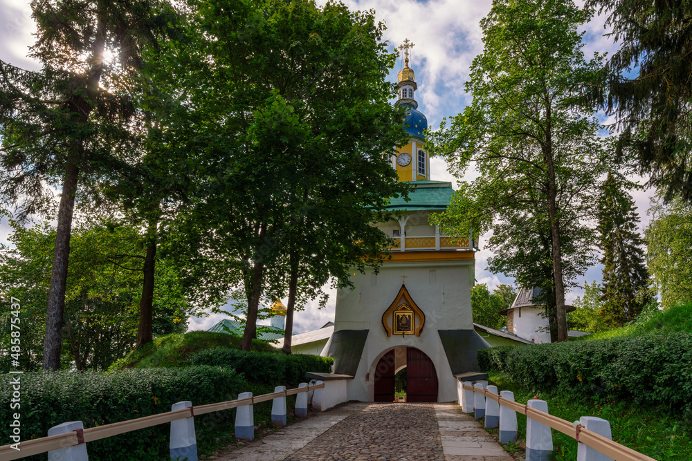 Fototapeta premium View of the main entrance of the Holy Dormition Pskov-Pechersk Monastery Petrovskaya Tower with entrance gates on a sunny summer day, Pechory, Pskov region, Russia