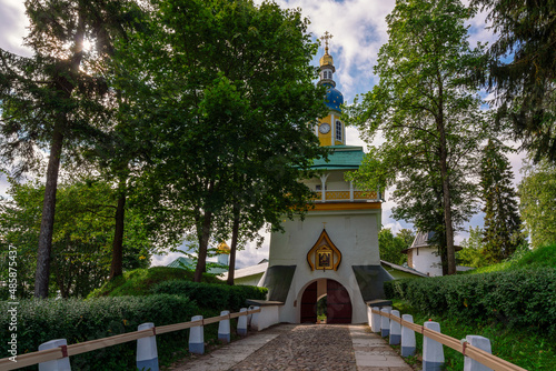 View of the main entrance of the Holy Dormition Pskov-Pechersk Monastery Petrovskaya Tower with entrance gates on a sunny summer day, Pechory, Pskov region, Russia