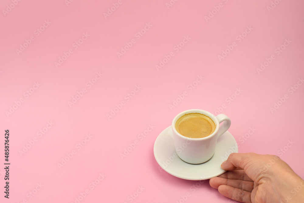 Woman Hand Holding Coffee Cup On Pink Background, top view, copy space. Cup of coffee in hand Woman Hand Holding Coffee Cup On Pink Background, top view, copy space. Cup of coffee in hand