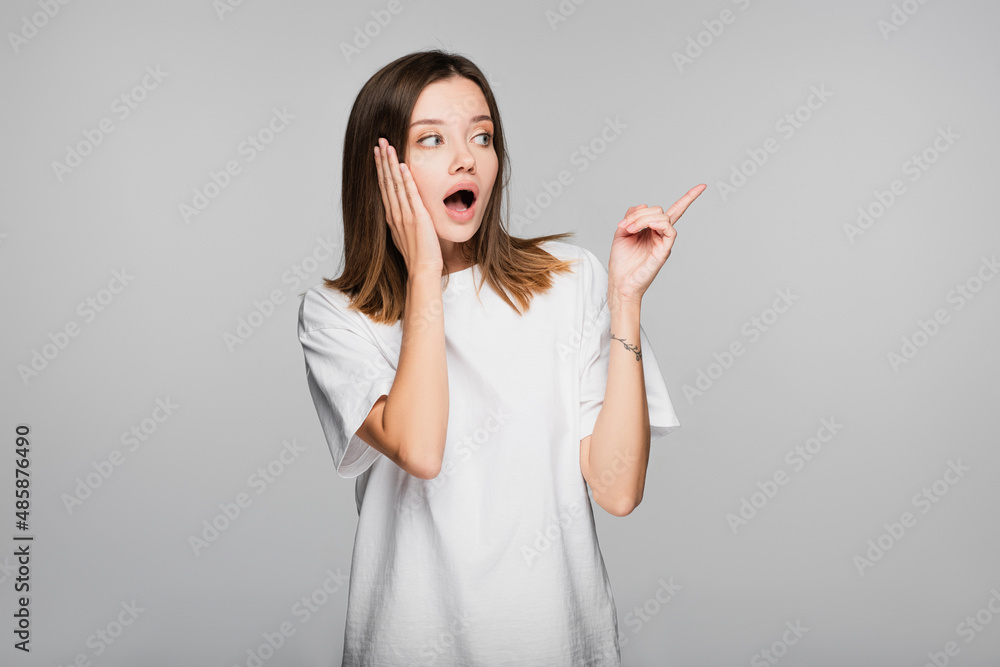 shocked woman touching head and pointing with finger isolated on grey shocked woman touching head and pointing with finger isolated on grey