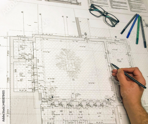 Architectural project design and sketching. Sketch pencils, glasses and male designer hand on map.