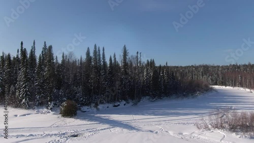 Drone flying over the frozen river Lozva, tree tops, dense wild forest, the road to the Dyatlov Pass photo