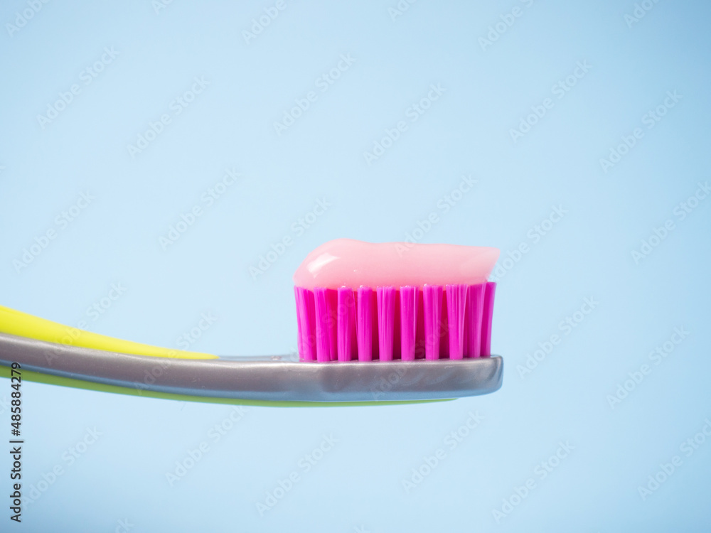 Toothbrush with pink toothpaste. Close up of pink toothpaste on a toothbrush. Toothbrush with pink toothpaste. Close up of pink toothpaste on a toothbrush.