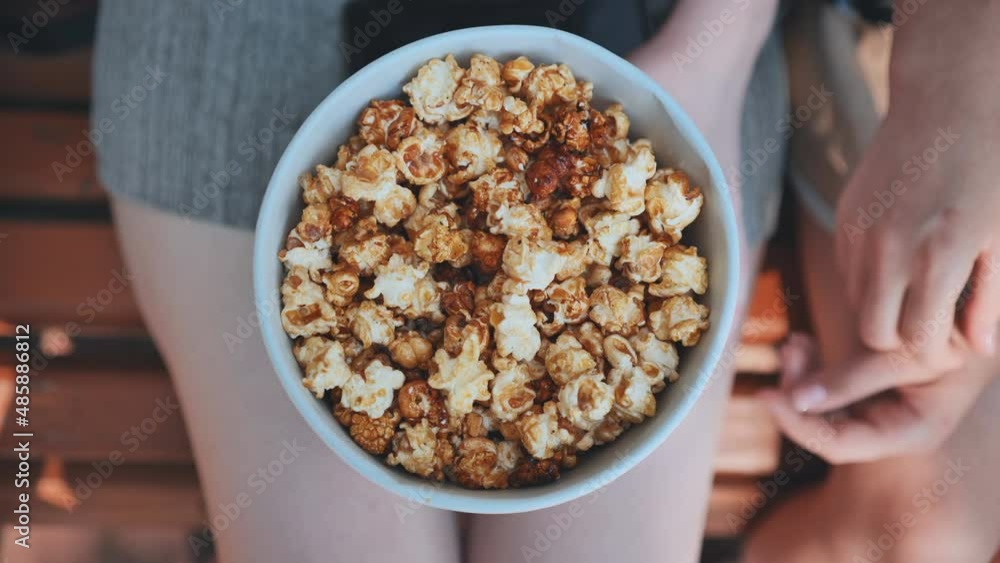 Friends eating popcorn on the street. Close-up of hands. Friends eating popcorn on the street. Close-up of hands.