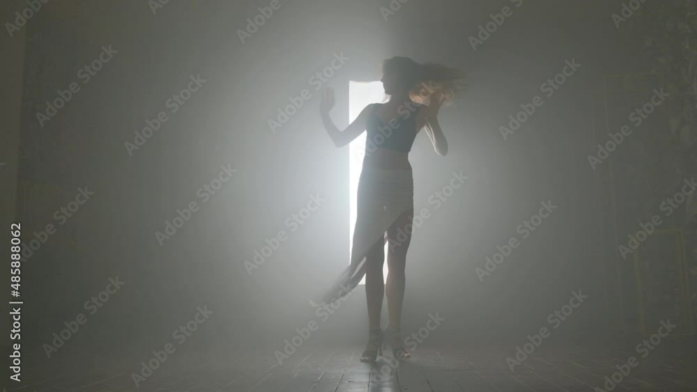 Woman dancing bachata dance indoors with smoke. Woman dancing bachata dance indoors with smoke.