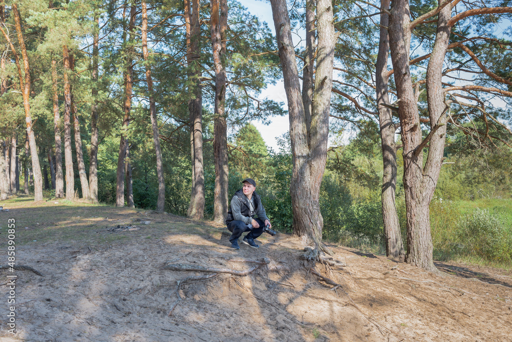 Fototapeta premium Man nature photographer taking pictures in the forest.