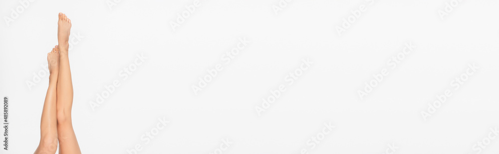 partial view of slim and smooth legs of young woman isolated on white, banner partial view of slim and smooth legs of young woman isolated on white, banner