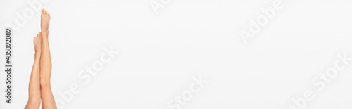 partial view of slim and smooth legs of young woman isolated on white  banner