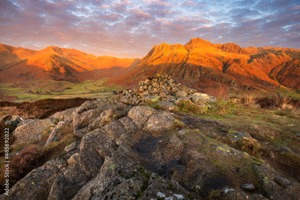 Beautiful sunrise with golden light on Lake District mountains taken from Side Pike. Langdale Pikes, UK.