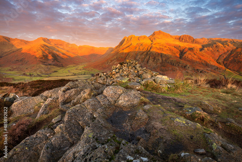 Beautiful sunrise with golden light on Lake District mountains taken from Side Pike. Langdale Pikes, UK.