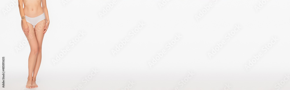 partial view of tattooed woman with slender legs on white background, banner