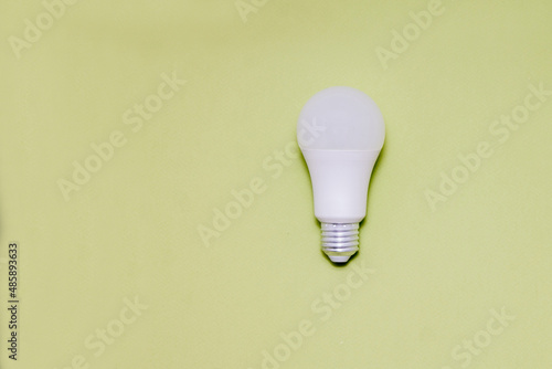 A light bulb on a light green background. Space for text. Copy space.