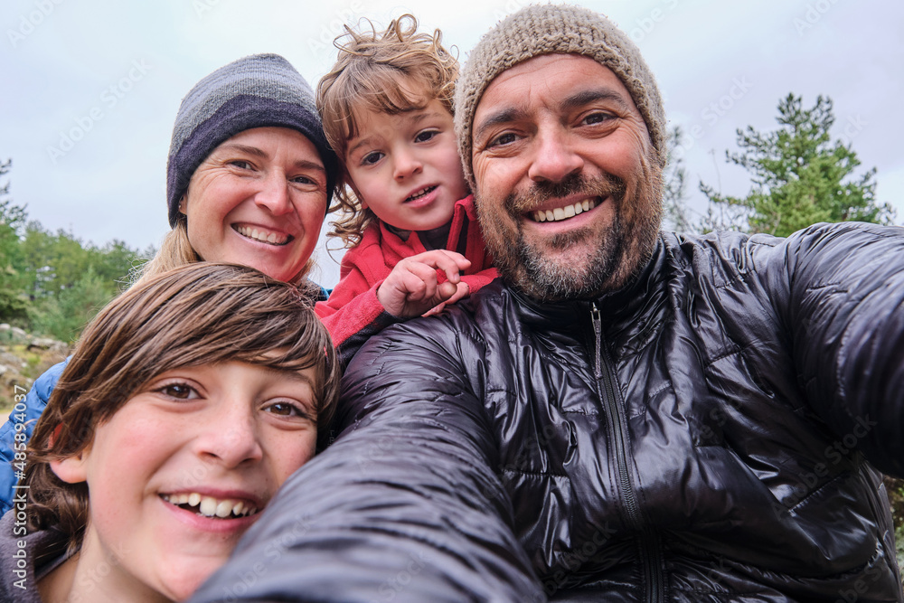 A happy family is relaxing and taking selfie in the mountain A happy family is relaxing and taking selfie in the mountain