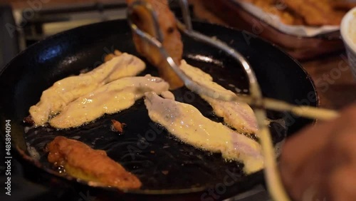 one person breading and frying fish pieces for Mexican-style tacos photo