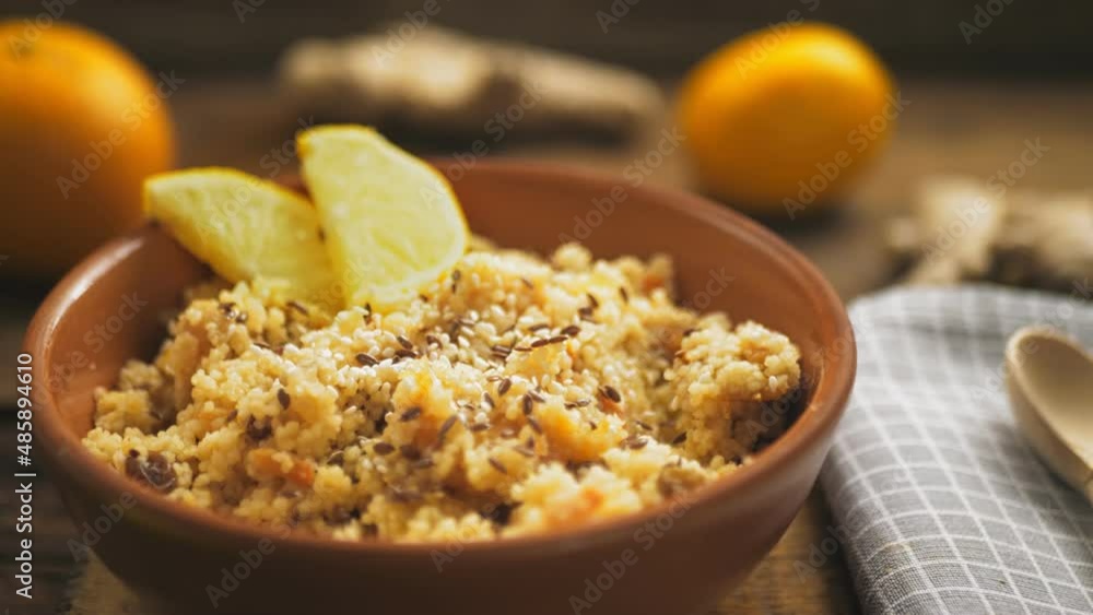 Couscous masfouf with dried fruits and nuts on a wooden board on a linen napkin next to a wooden spoon. close-up Panorama Couscous masfouf with dried fruits and nuts on a wooden board on a linen napkin next to a wooden spoon. close-up Panorama