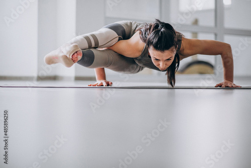 Woman practising yoga in the gym on a mat