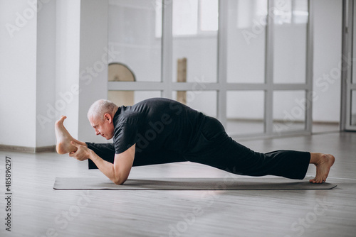 Man practising yoga in the gym