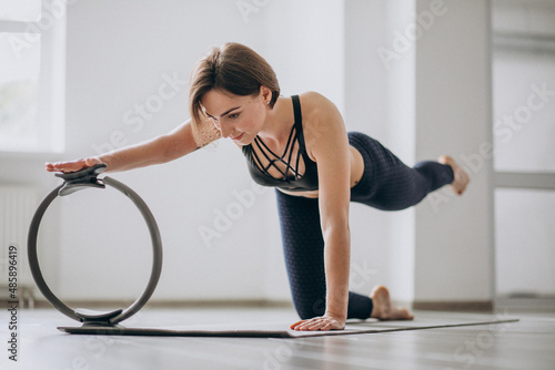 Woman practising yoga in the gym on a mat