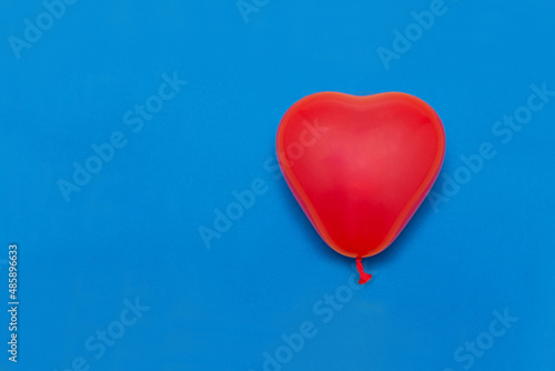 A balloon in the form of a red heart on a blue background. Valentine's day. Love.
