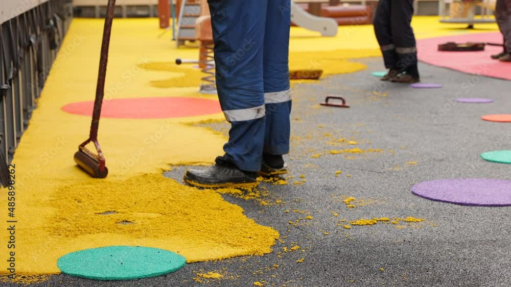 Rubber coating for playgrounds applied on the surface by a steel roller tools. PDM rubber granules. Floor covering for sports. Rubber mulch for safety and injury prevention. Selective focus. Rubber coating for playgrounds applied on the surface by a steel roller tools. PDM rubber granules. Floor covering for sports. Rubber mulch for safety and injury prevention. Selective focus.