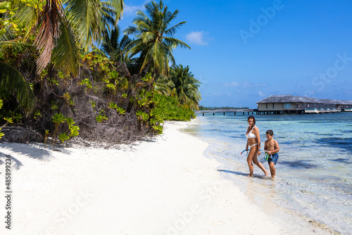 Fototapeta Naklejka Na Ścianę i Meble -  Mother and son getting out of the water on a beach in the Maldives