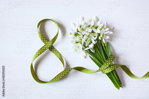 Obraz na plátně Geeting card for Women's day march 8, number eight from a green ribbon and a bou