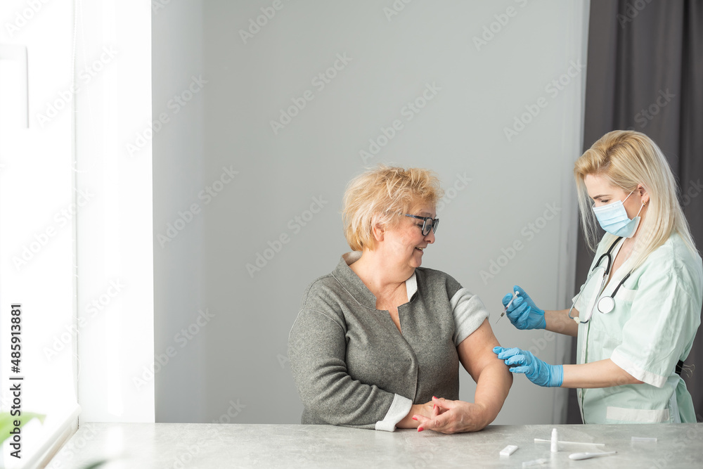 Obraz premium close up doctor holding syringe before make injection to patient in medical mask. Covid-19 or coronavirus vaccine