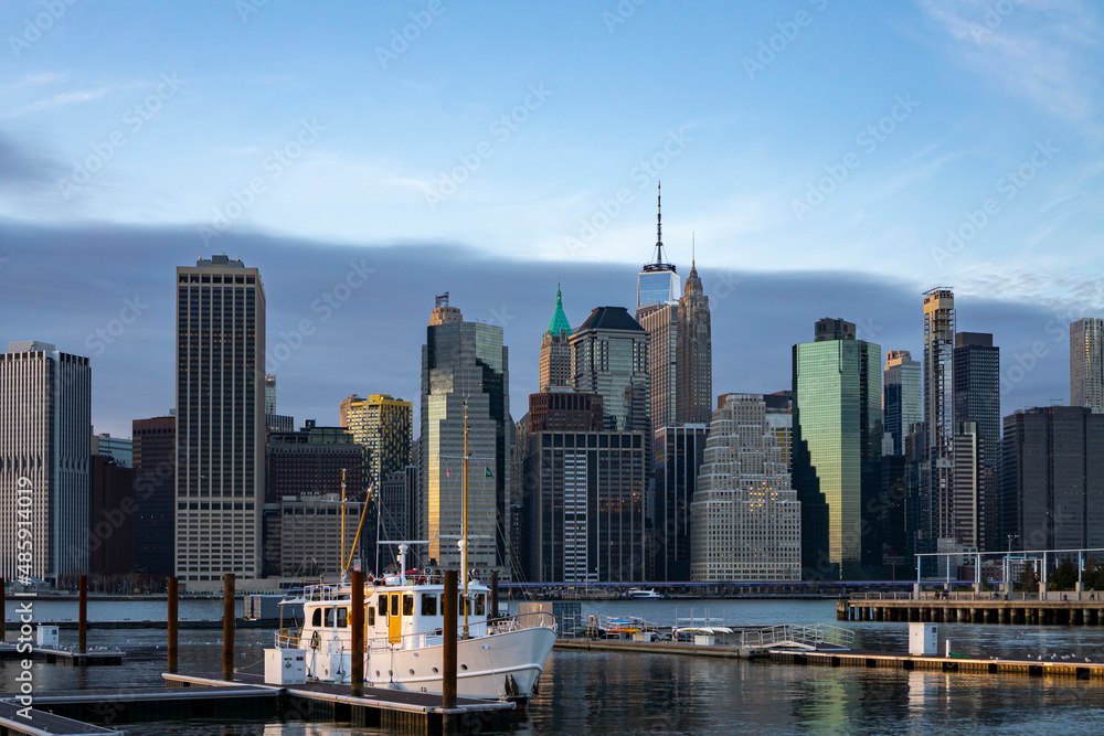 Financial district skyline of downtown New York City shot from pier over East River