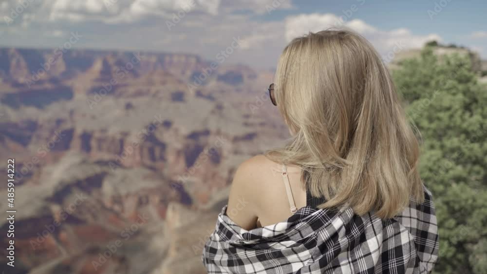 A young woman looking to Horseshoe Bend and Colorado river from the edge of 1000ft canyon in Glen Canyon National Recreation Area, Arizona, USA A young woman looking to Horseshoe Bend and Colorado river from the edge of 1000ft canyon in Glen Canyon National Recreation Area, Arizona, USA