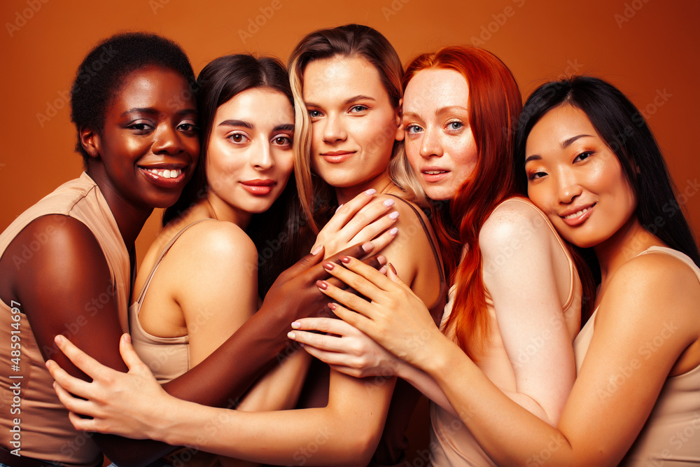 Obraz premium young pretty caucasian, african, scandinavian woman posing cheerful together on brown background, lifestyle diverse nationality people concept