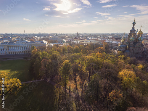 Aerial view of the cathedral Church of the Savior on Blood and park Mikhaylovskiy at sunset, golden dome, roofs of St. Petersburg, shadows of trees, autumn,  photo