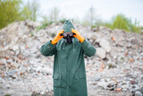A man in a protective mask and protective clothing explores the danger zone. Ecological catastrophe. selective focus