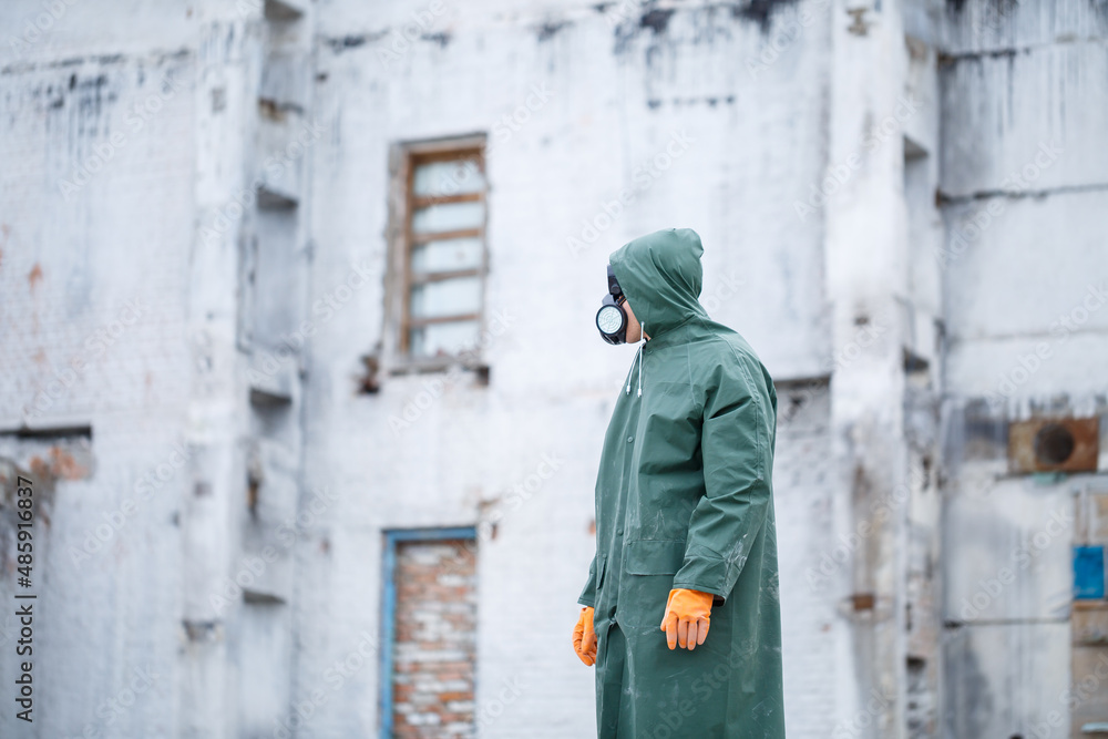A man in a protective mask and protective clothing explores a dangerous radioactive area.