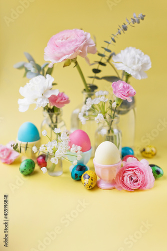 Easter eggs, flowers on yellow background