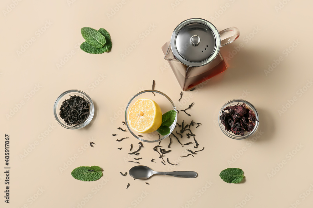 Composition of teapot with tasty tea and glass with lemon on yellow background Composition of teapot with tasty tea and glass with lemon on yellow background