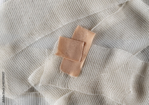 Adhesive bandage on medical bandage background and texture, top view