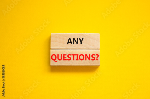 Any questions symbol. Concept words Any questions on wooden blocks on a beautiful yellow table yellow background. Business and Any questions Q and A concept, copy space.