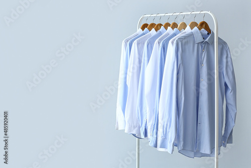 Rack with clean shirts on grey background photo