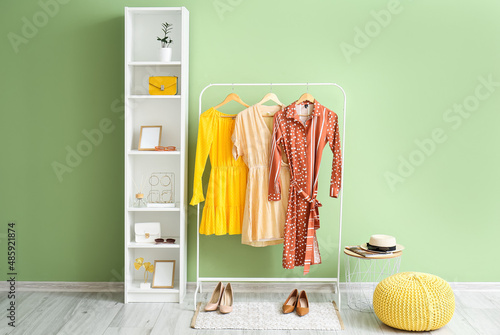 Interior of room with hanger and shelf unit near color wall