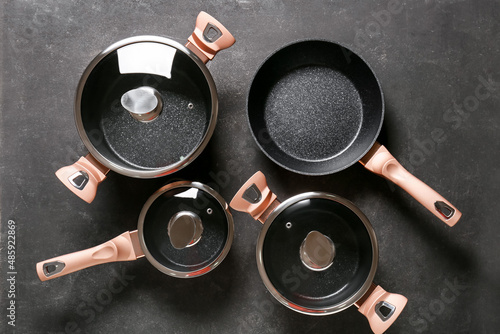 Set of cooking pots and saucepans on dark background