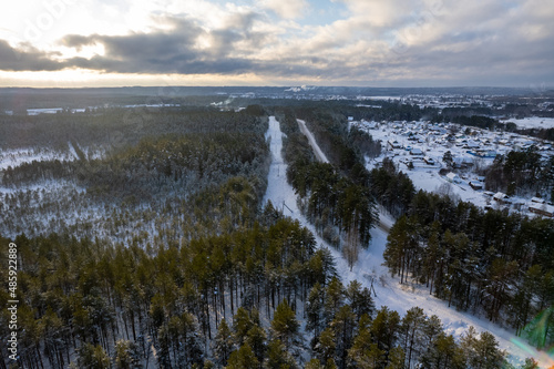 Fototapeta Naklejka Na Ścianę i Meble -  aerial view forest tundra taiga road in the forest in winter on a sunny frosty day in siberia small village. High quality photo