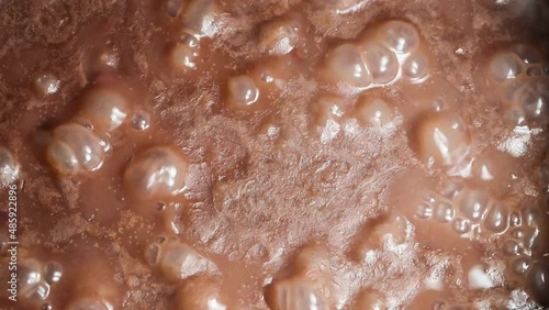 Closeup of red beans cooking in stone pot.