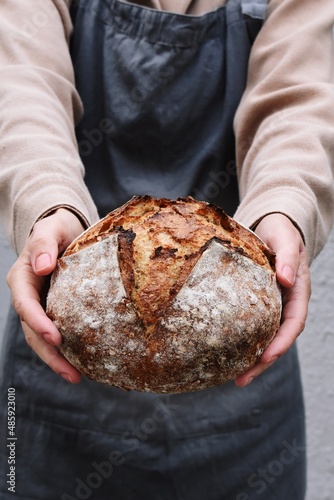 Baker holding sourdough bread. Artisan bread 