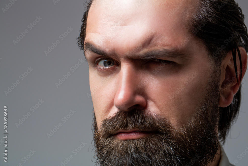Obraz premium Solid man with beard and mustache. Closeup portrait of athletic bearded man. Handsome stylish bearded man. Sexy male, macho, long beard. Attractive caucasian bearded hipster