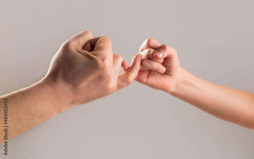 Child hook little finger together. Little finger of the two hands hold together. Show friendship and forgiveness. Friendship of generations. Father, daughter hand making promise friendship concept Child hook little finger together. Little finger of the two hands hold together. Show friendship and forgiveness. Friendship of generations. Father, daughter hand making promise friendship concept
