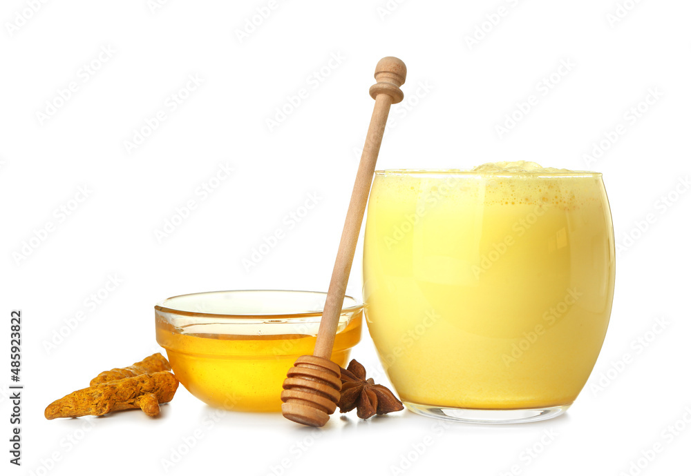 Glass of delicious turmeric latte with honey and star anise on white background Glass of delicious turmeric latte with honey and star anise on white background