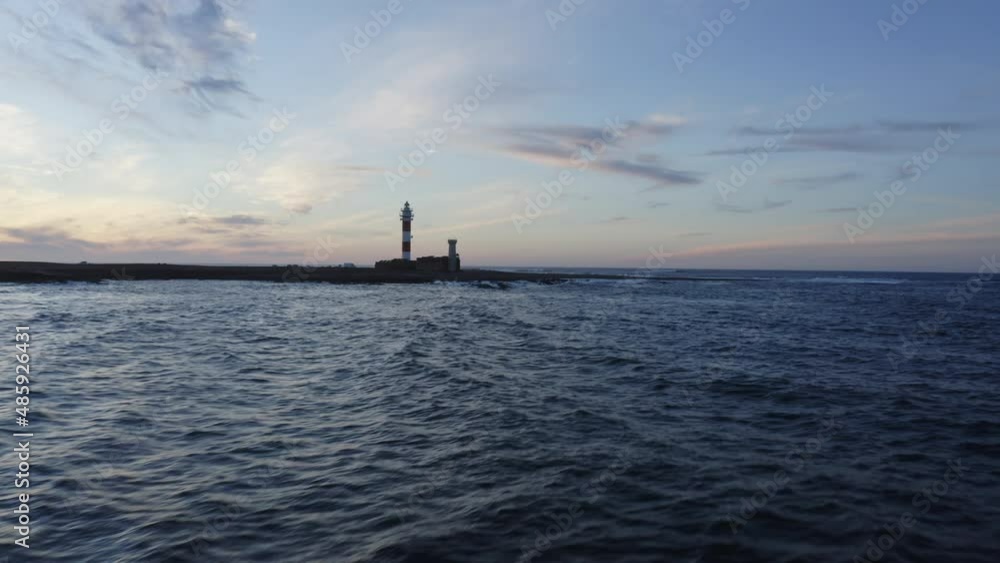 Dramatic aerial drone shot of waves closing up to a lighthouse by the Atlantic ocean in Fuerteventura Canary islands Dramatic aerial drone shot of waves closing up to a lighthouse by the Atlantic ocean in Fuerteventura Canary islands