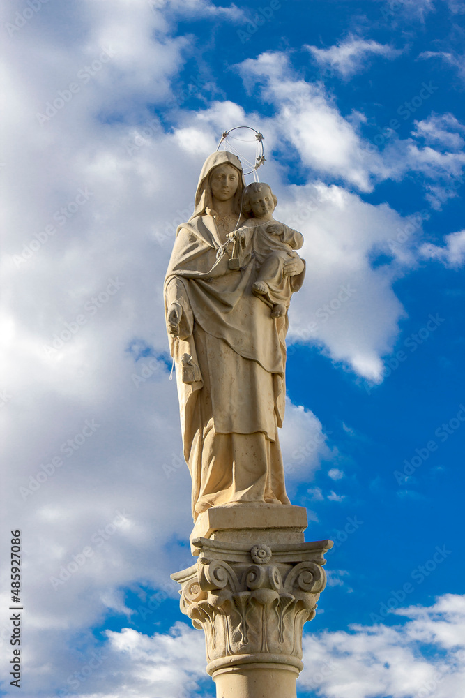 religious statue of the virgin with blue sky background