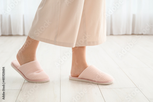 Young woman in soft comfortable slippers at home